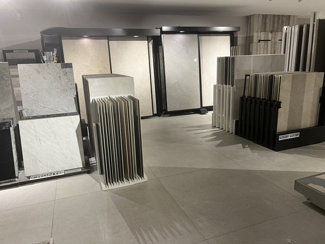 Utställning hos Pronto Kakel i Vellinge med stora plattor och materialprover i ställ och på väggpaneler.