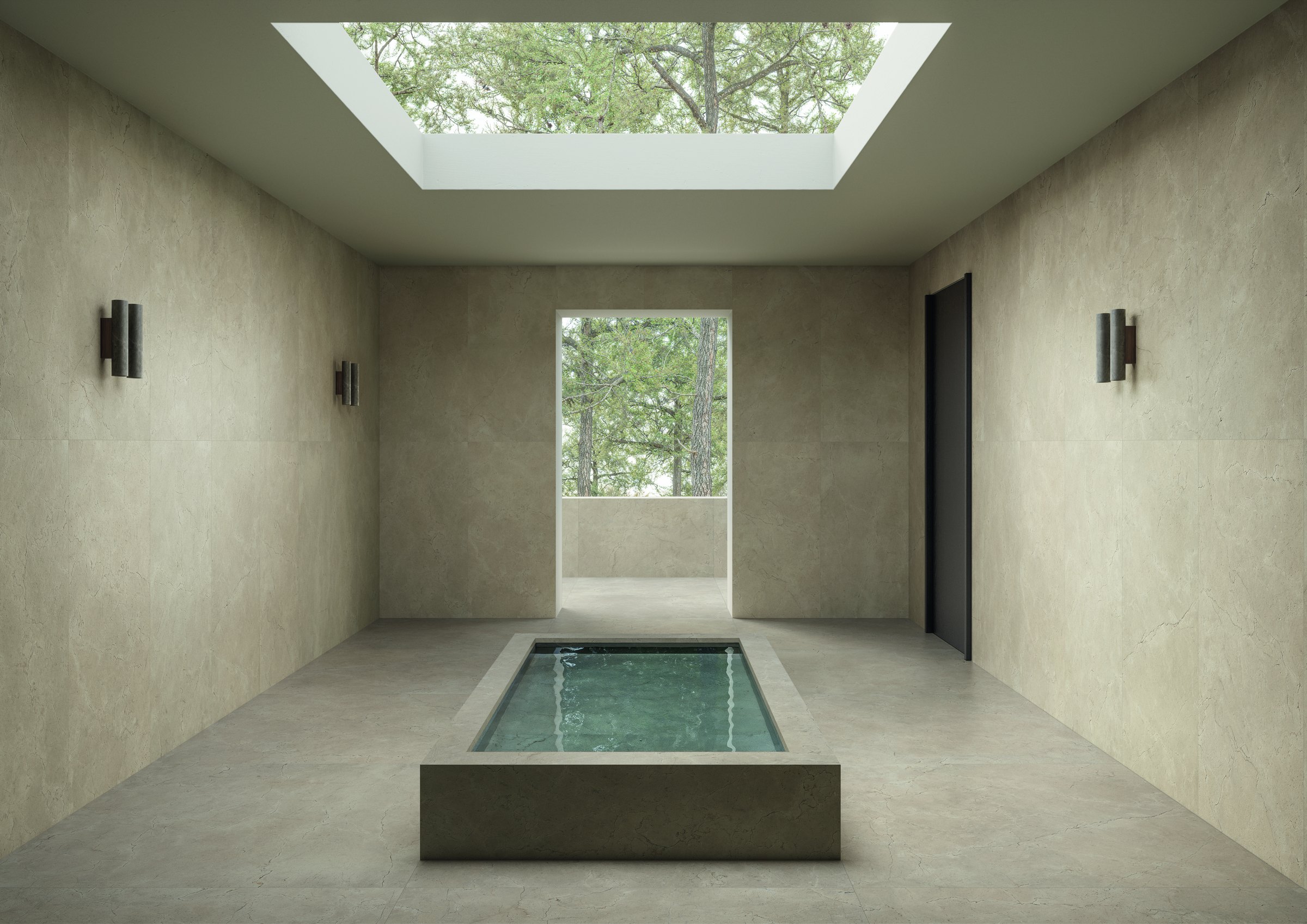 Spa med kalkstensliknande klinker på golv och väggar, en liten inomhuspool och stort takfönster.